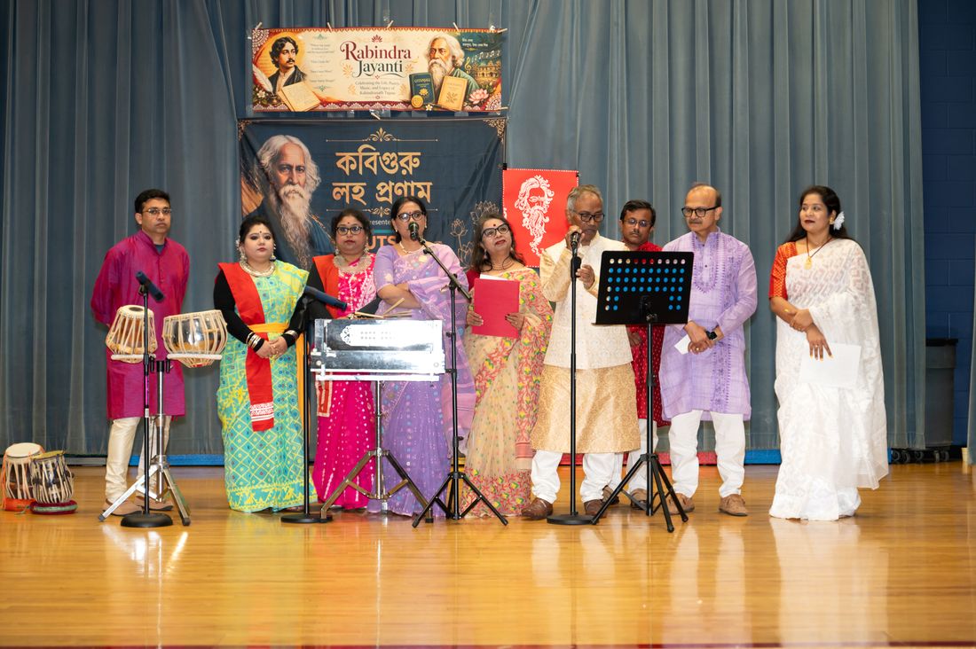 Singers and musicians performing on stage at Utsav & Adda's Rabindra Jayanti 2026 celebration, with a Rabindra Jayanti banner behind them