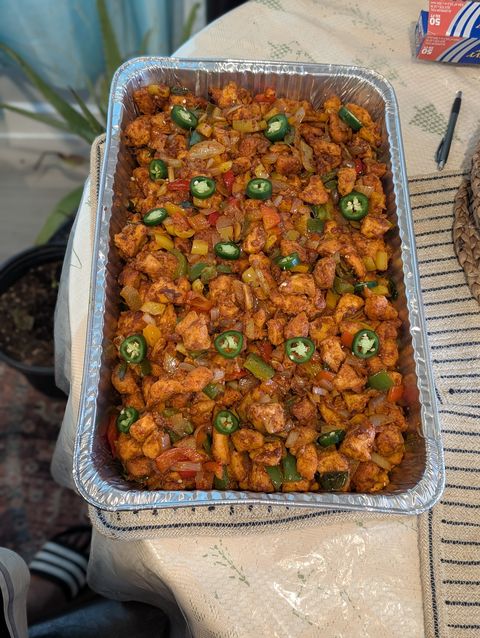 A tray of prepped chicken ready to be cooked for a festival food court