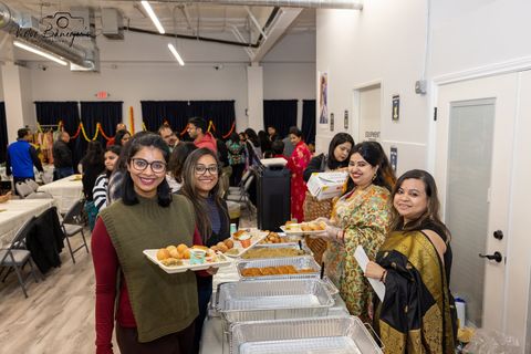 Three guests smiling with festival plates at Poush Parbon 2026