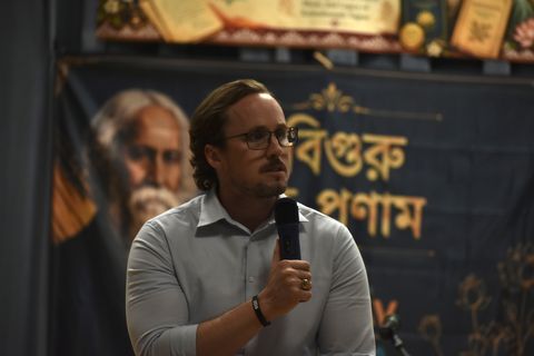 A speaker addressing the audience with a microphone at Rabindra Jayanti 2026
