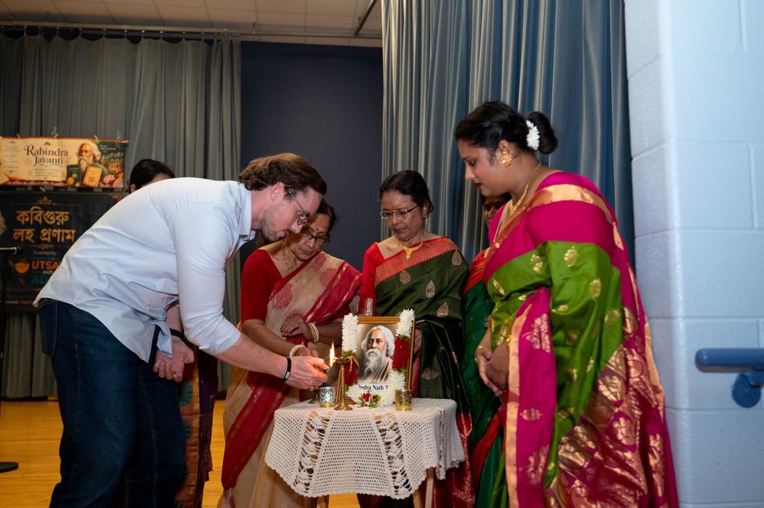 A diya-lighting ceremony in front of a portrait of Rabindranath Tagore at Utsav & Adda's Rabindra Jayanti 2026 celebration in Houston